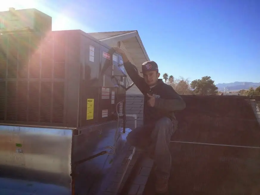 HVAC technician performing Air Duct Repair on a rooftop unit in Forest Hill